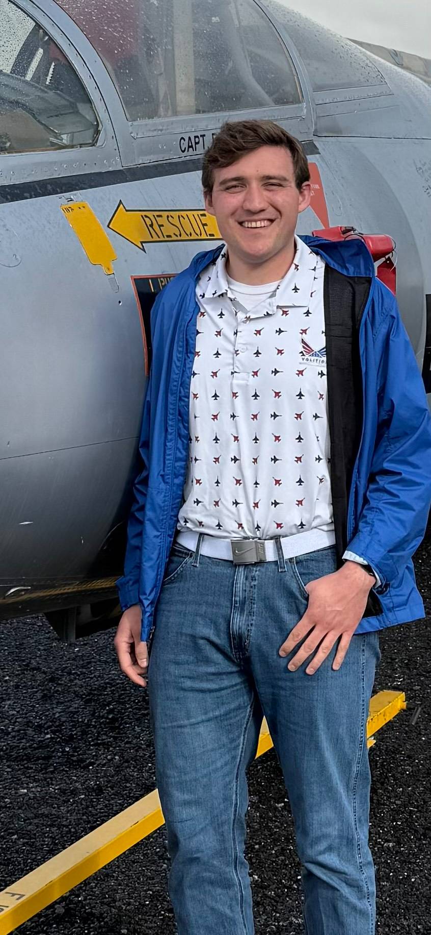 Nick standing next to an airplane and smiling